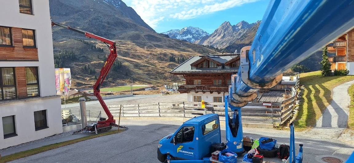 Montage der Weihnachtsbeleuchtung an einer Fassade mit hydraulischem Steiggerät
