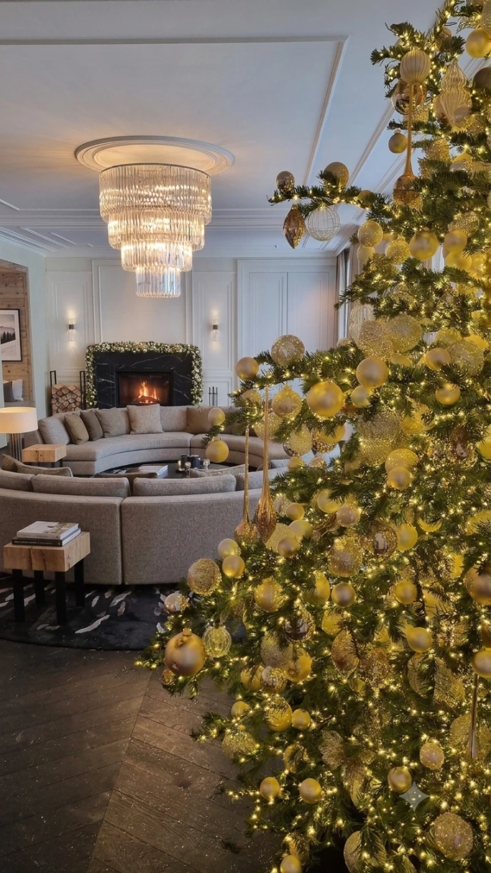 Weihnachtlich dekorierte Hotellobby in Tirol mit Christbaum im Vordergrund und dekoriertem Kamin im Hintergrund